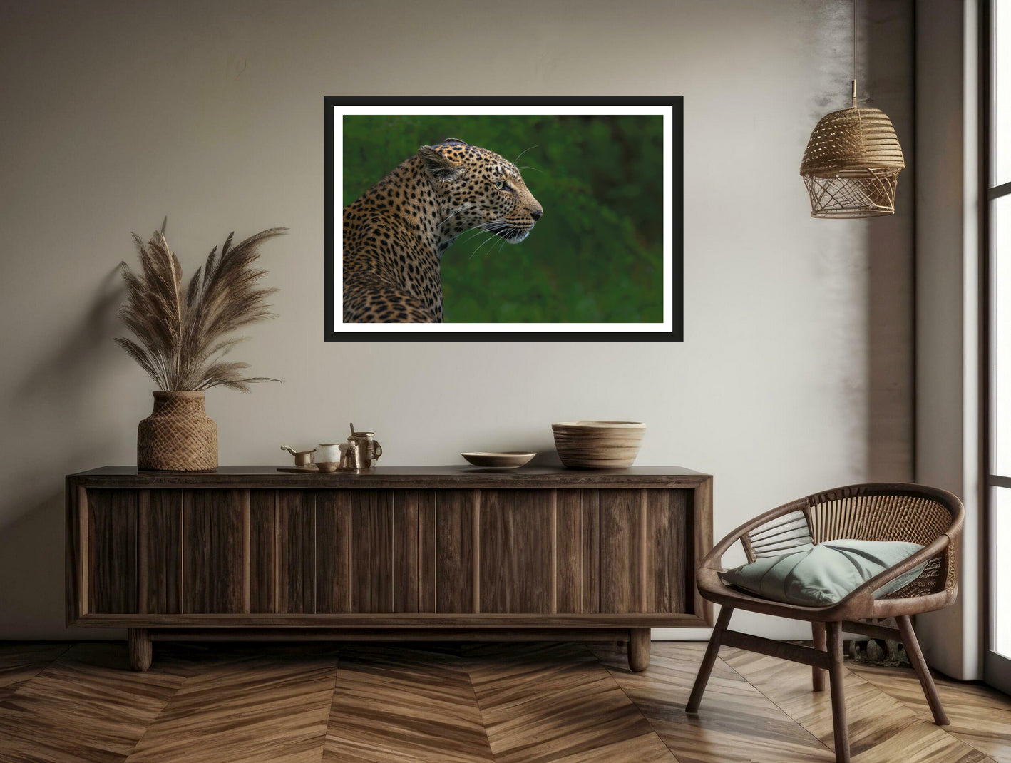 A closeup photograph of a leopard with blurred green background hanging on a brown wall above a commode and a chair.