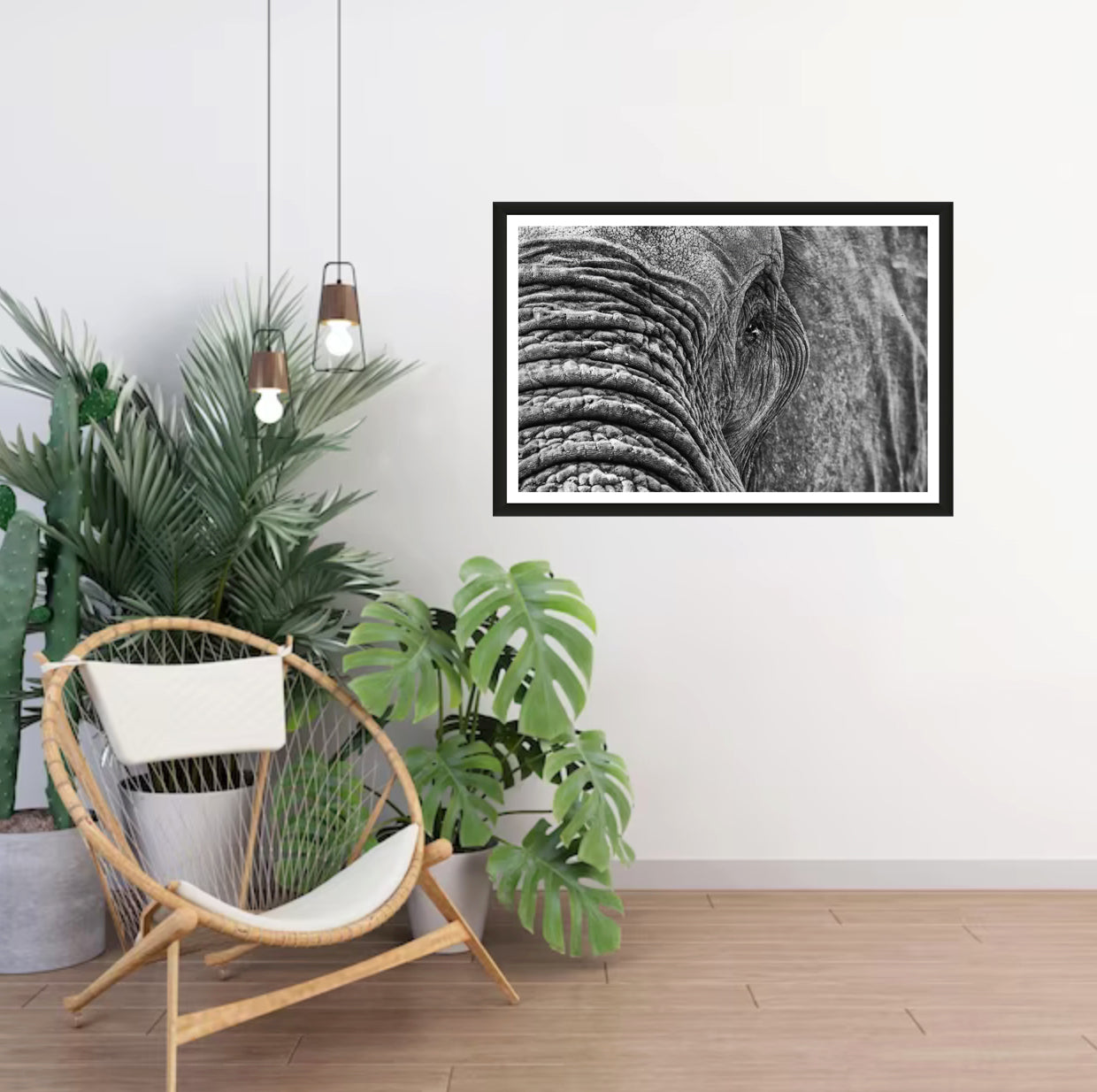 A closeup photograph of an African elephant’s eye and texture of its skin in black and white hanging on a white wall in a room with a chair and plants next to it.