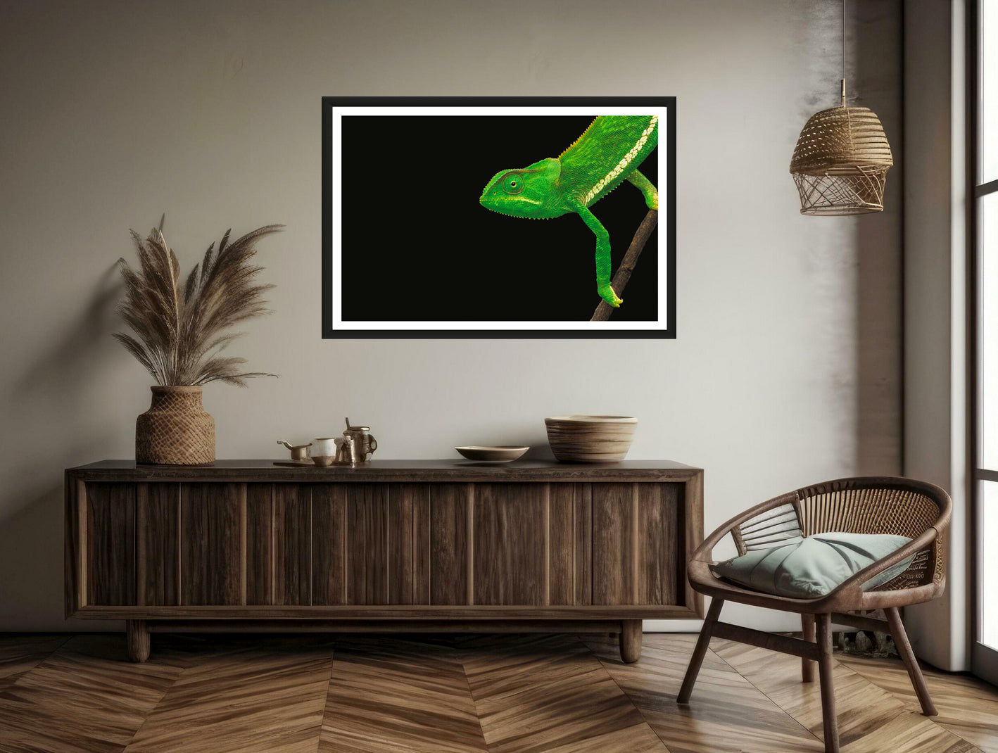 A photograph of a green chameleon walking into the frame hanging on a brown wall above a chair and a commode.